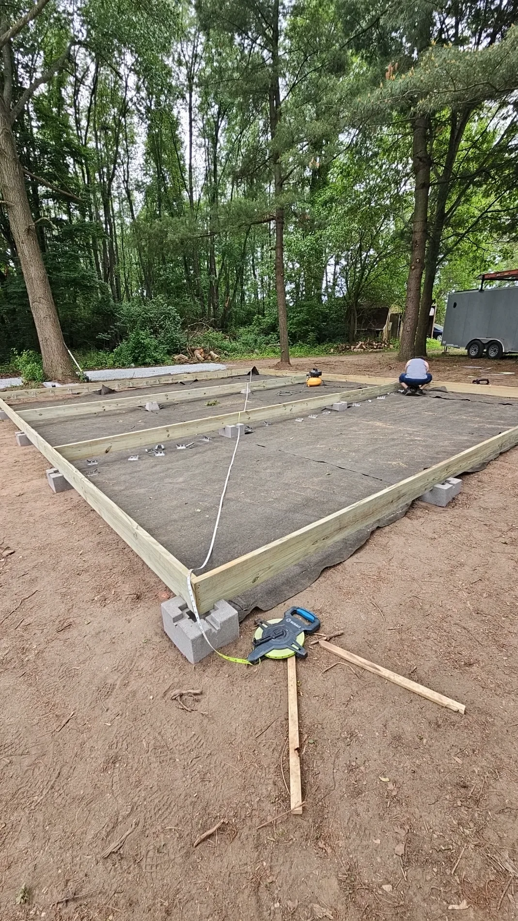 Gravel pad foundation framed with timber on leveled ground for site preparation